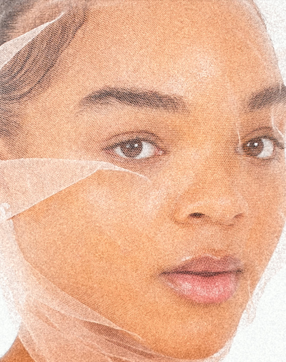 A close editorial portrait shot through fine tulle
