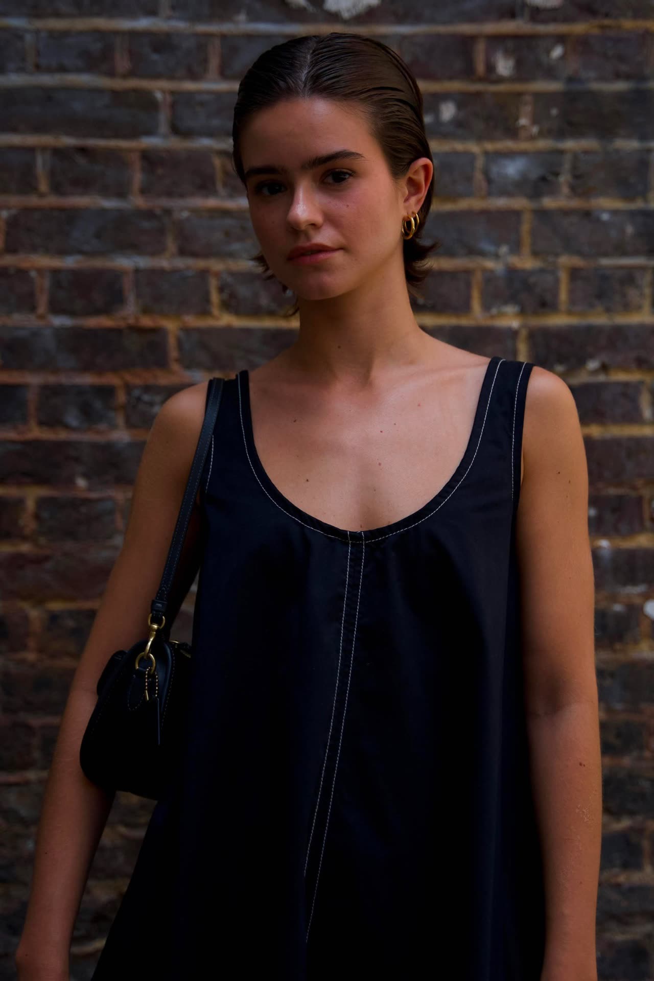 A London townhouse street with a figure in a yellow crop top and cargo trousers